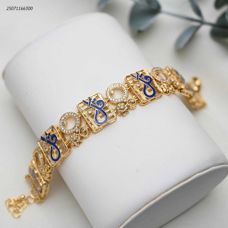 سوار عريضة عبارة عن قطع مربعة متشابكة مع زركون و كتابة بخط كحلي كلمة قل لون ذهبي