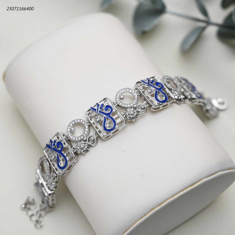 سوار عريضة عبارة عن قطع مربعة متشابكة مع زركون و كتابة بخط كحلي كلمة قل لون فضي