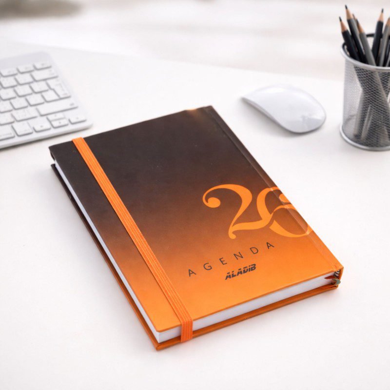 أجندة 2026 من أديب بتصميم مموج لون برتقالي مقاس 12*17 سم